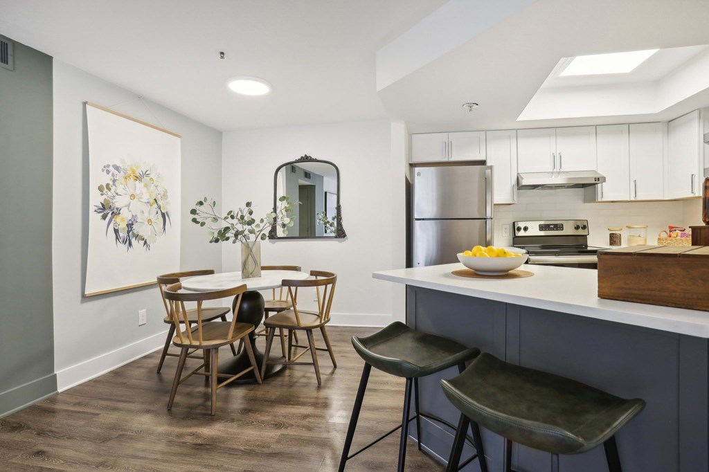 A kitchen with a dining table and chairs.
