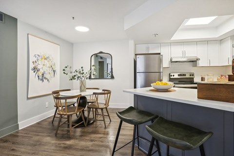 A kitchen with a dining table and chairs.