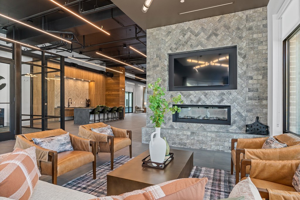 A living room with a stone fireplace and a flat screen TV mounted above it.