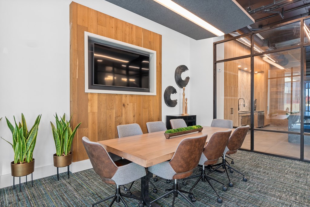 A conference room with a wooden table and chairs.