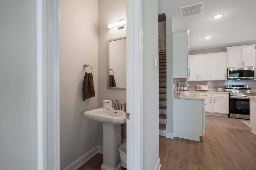 A bathroom with a sink and mirror is shown.
