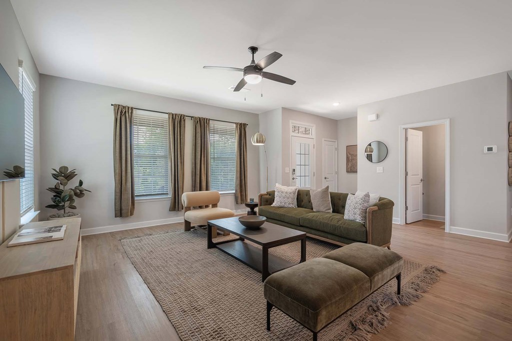 A living room with a brown rug and a green couch.