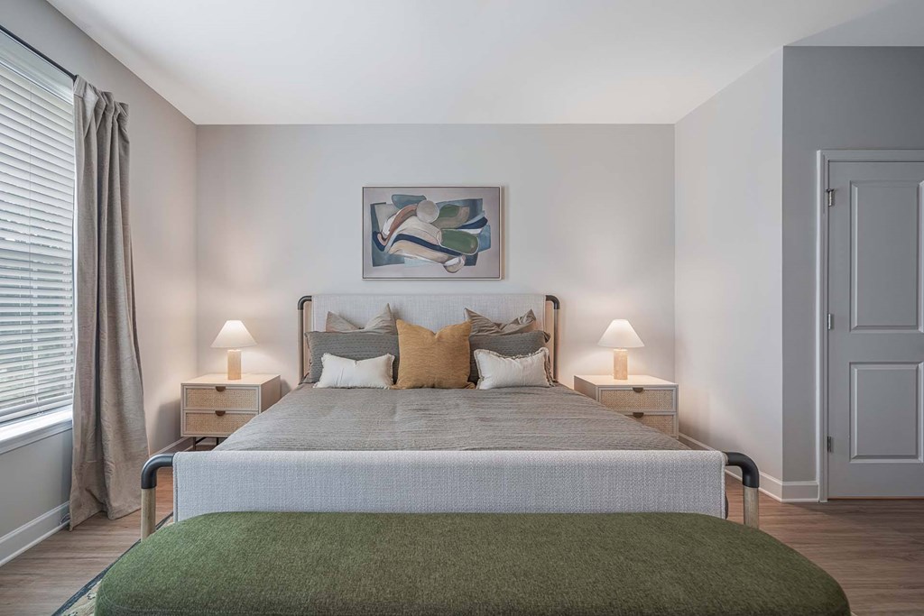 A bedroom with a large bed and a green blanket.