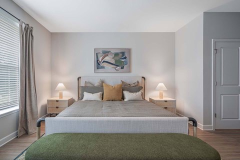 A bedroom with a large bed and a green blanket.