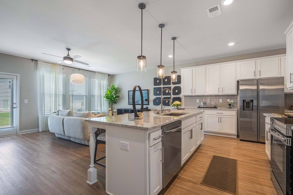 A modern kitchen with a large island and stainless steel appliances.