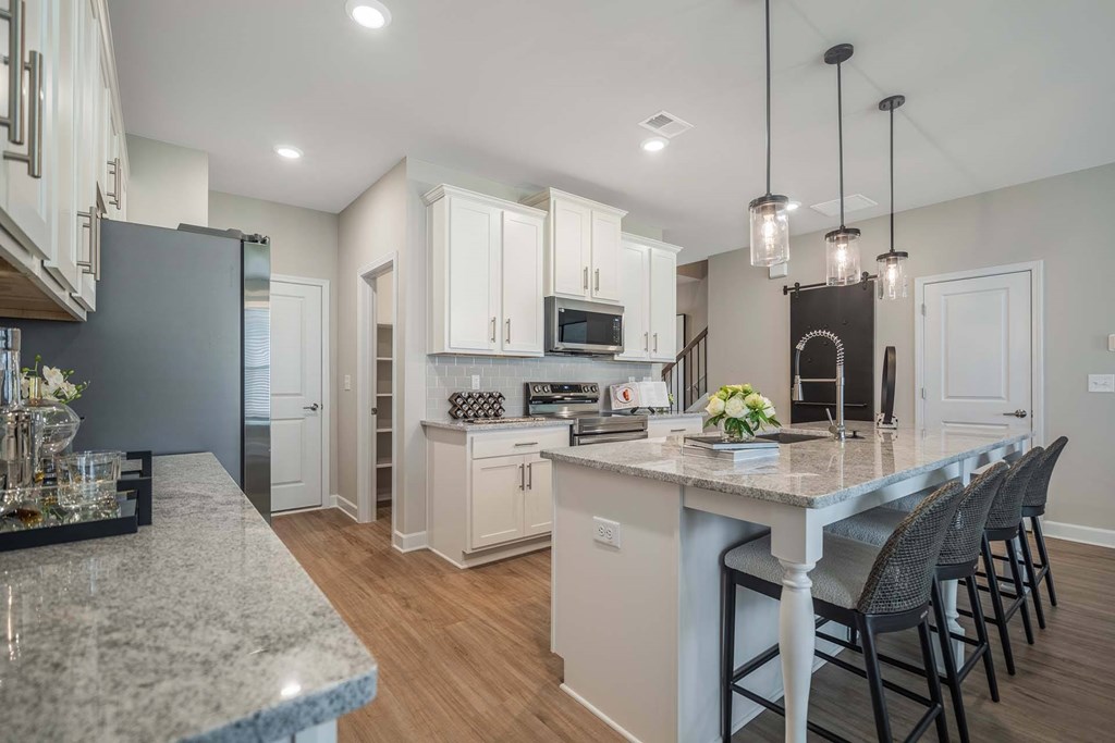 A kitchen with a marble countertop and white cabinets.