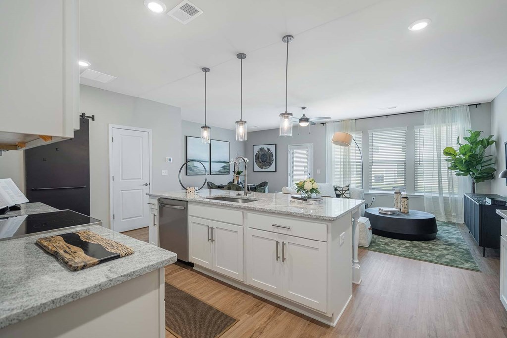 A modern kitchen with a granite countertop and white cabinets.