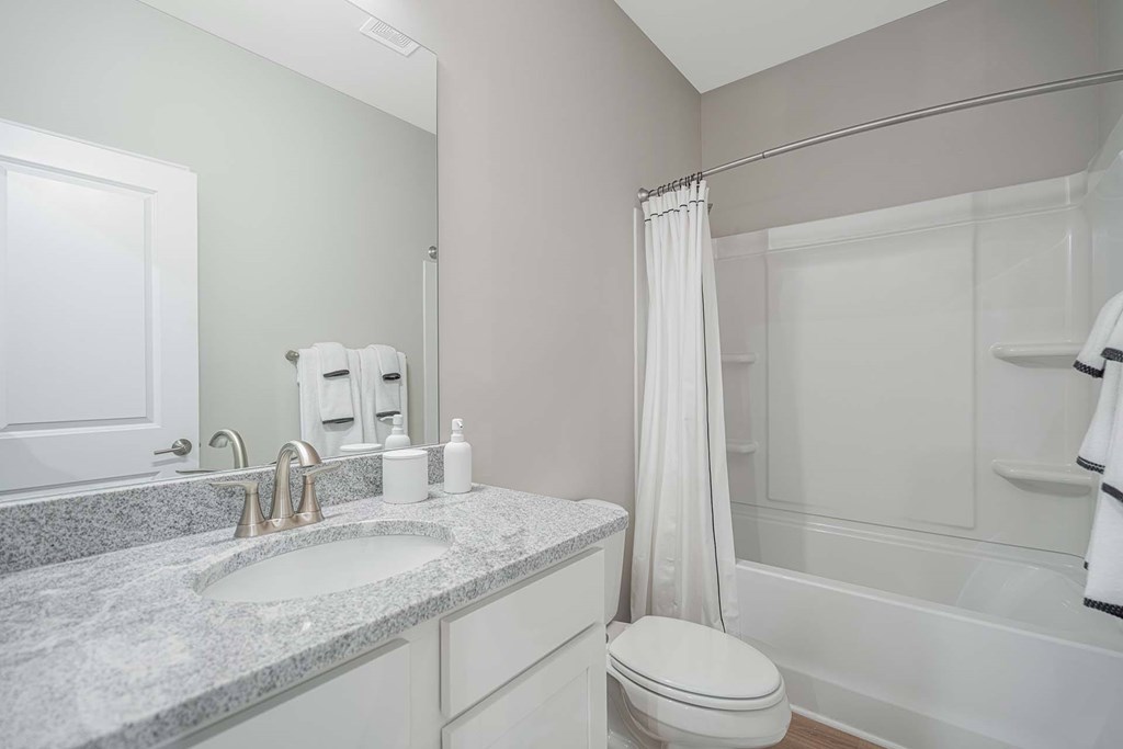 A bathroom with a sink, toilet, and bathtub.