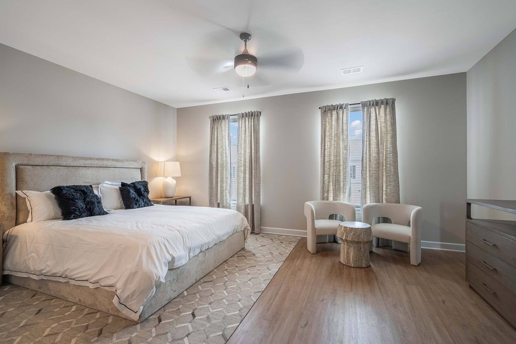 A bedroom with a large bed and a ceiling fan.