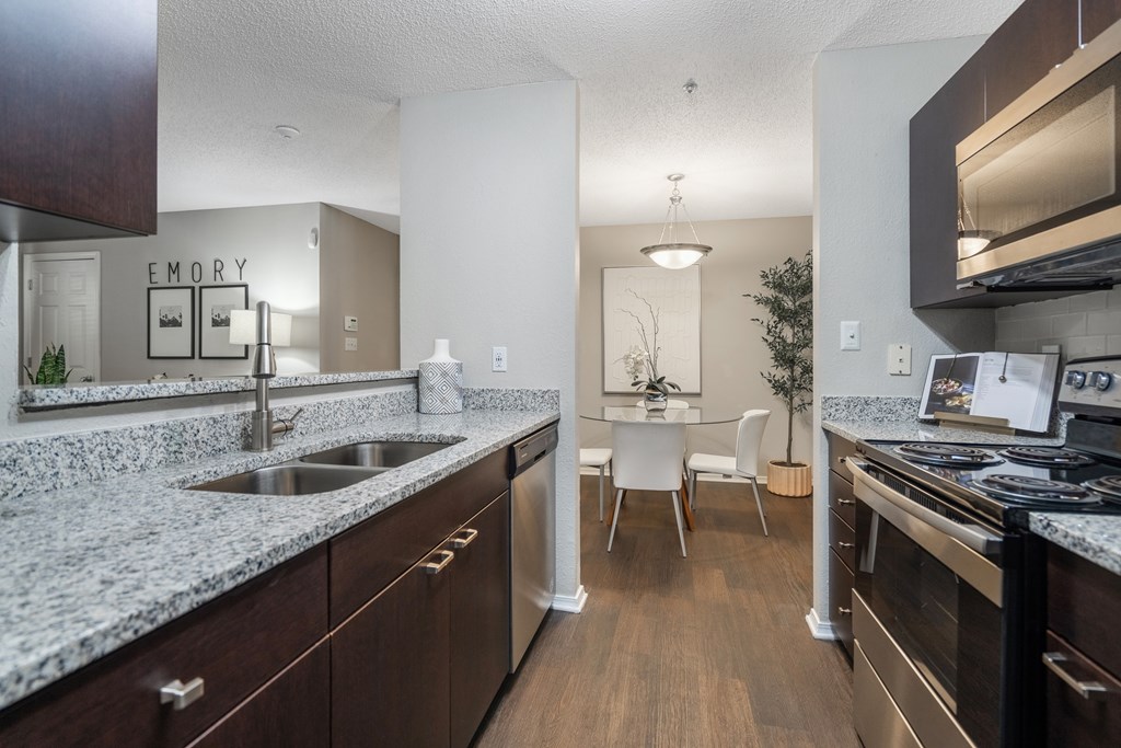 A kitchen with granite countertops and stainless steel appliances.