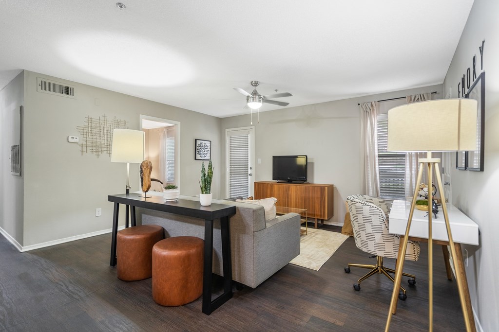 A living room with a grey couch, a black table, and a white chair.