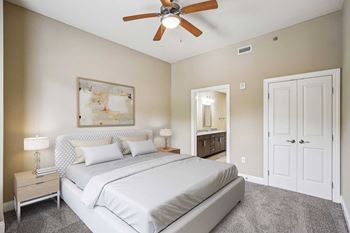 A bedroom with a large bed and a ceiling fan.