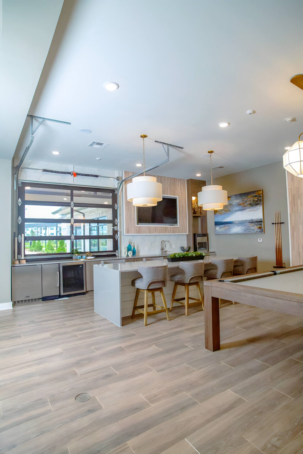 a kitchen and dining area with a bar and a large window