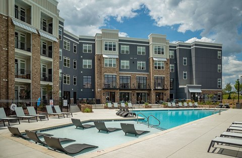 A large swimming pool in front of apartment buildings.