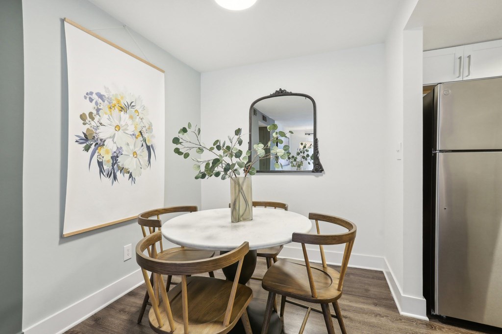 A dining room with a white table and chairs.
