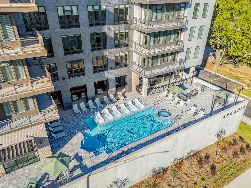 A large building with a pool in front of it.