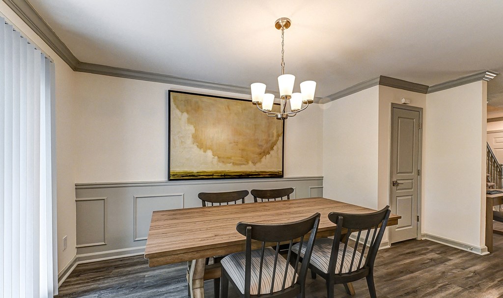 a dining room with a large painting on the wall