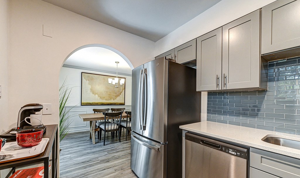 a kitchen with white cabinets and stainless steel appliances
