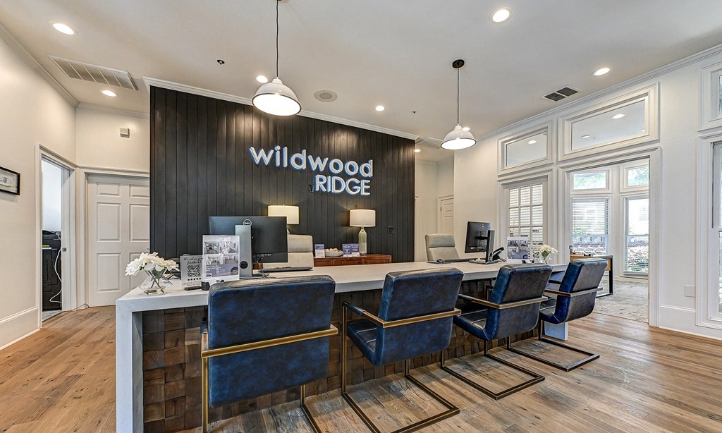 a reception desk with blue chairs and a large sign that says wildwood ridge