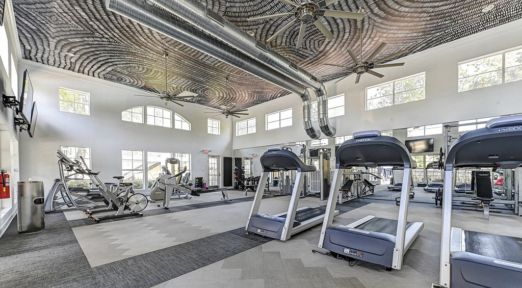 a spacious fitness center with treadmills and other exercise equipment
