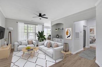 A living room with a white couch, a wooden coffee table, and a ceiling fan.