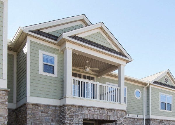 a green house with a roof and a porch