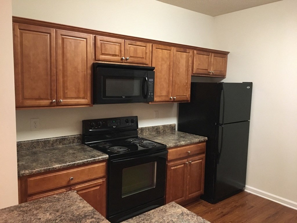a kitchen with black appliances and wooden cabinets