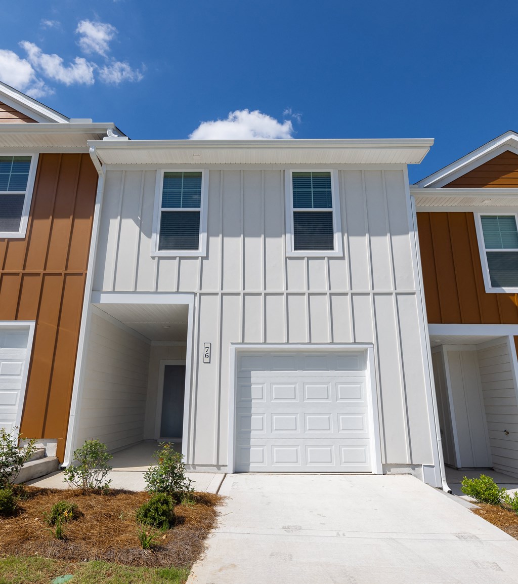 a house with a white garage door and brown and orange siding