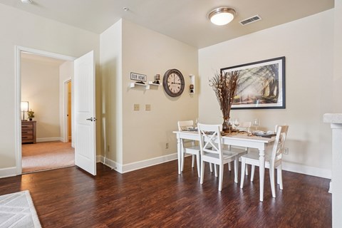 A dining room with a white table and chairs.