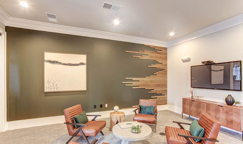 a living room with a tv and chairs