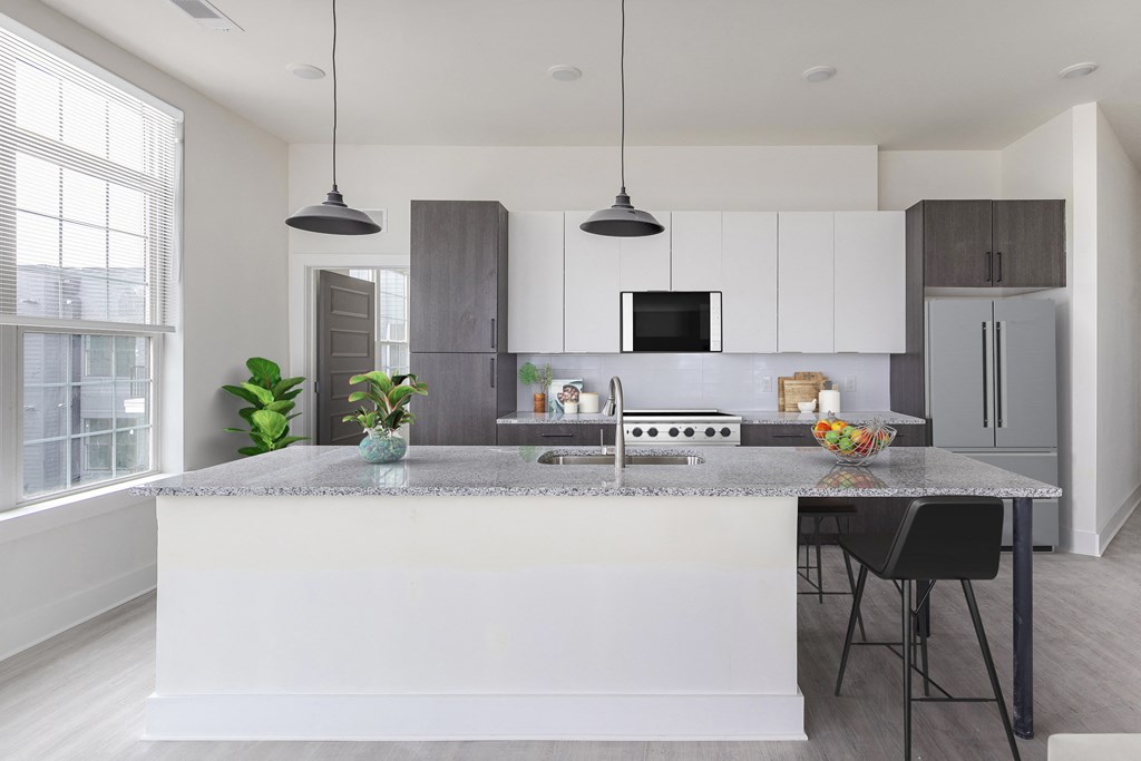 a kitchen with white cabinets and a marble counter top