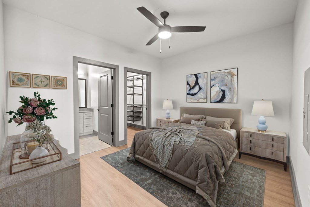 A bedroom with a bed, nightstands, and a ceiling fan.