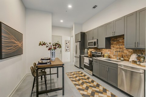 A kitchen with a table and chairs and a painting on the wall.
