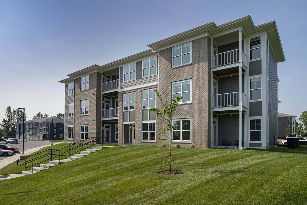 A large apartment building with a tree in front of it.