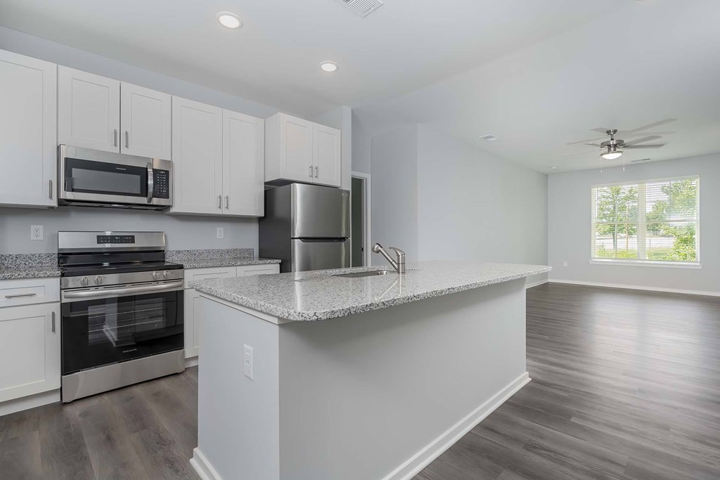 A kitchen with white cabinets and a large island.