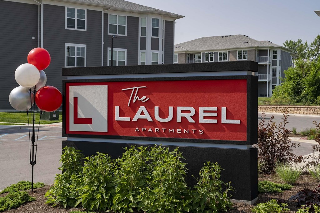 A sign for The Laurel Apartments is displayed in front of a building.