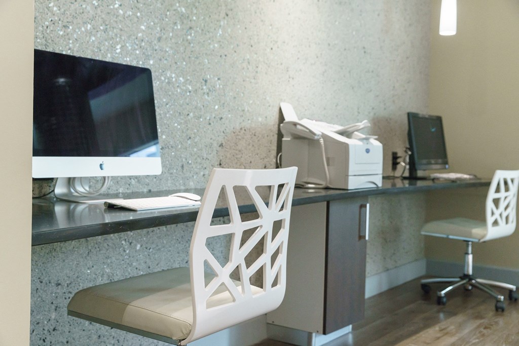 a desk with a computer and a chair in a hotel room