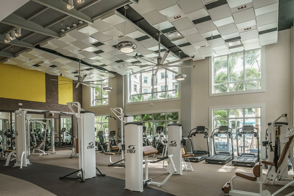 a gym with a lot of exercise equipment and windows