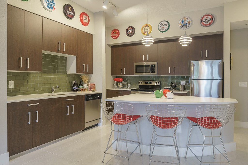 a kitchen with a center island and a stainless steel refrigerator