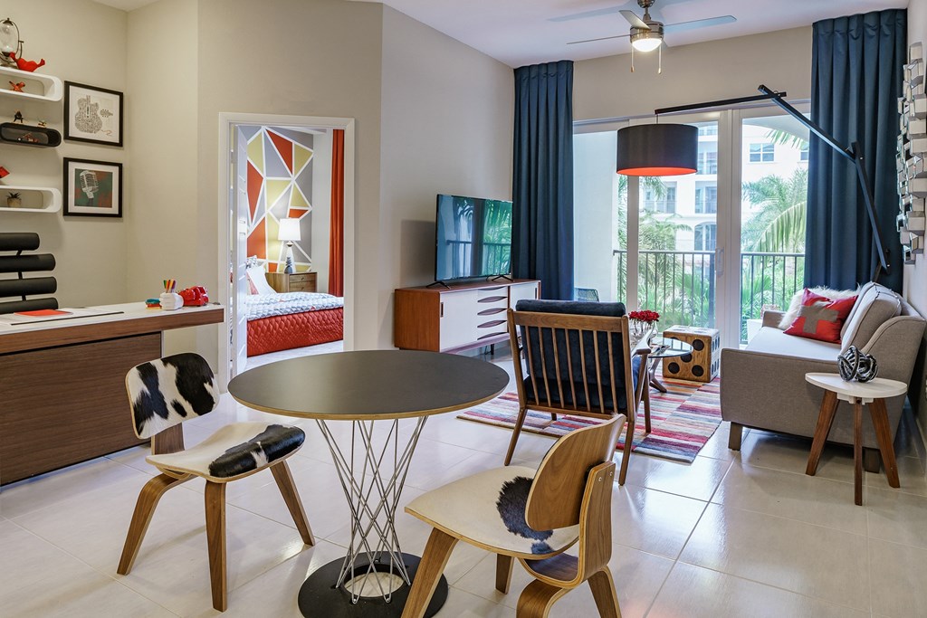 a living room and dining room with a bedroom in the background