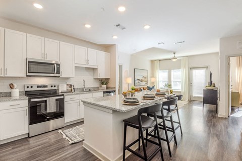 A modern kitchen with a bar area and a dining table set for four.