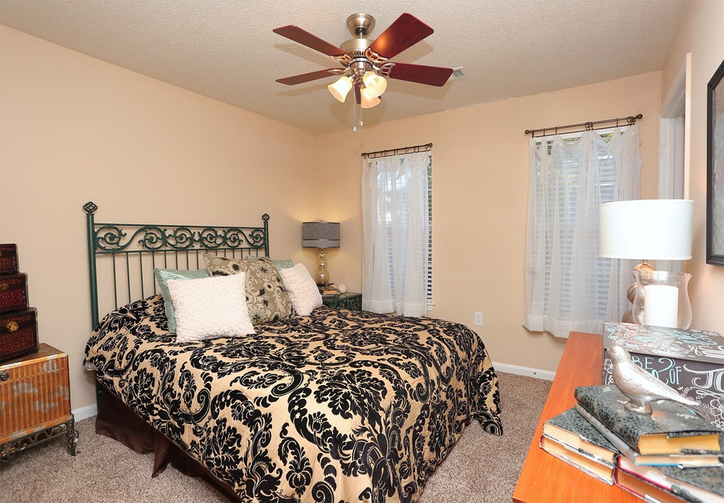 a bedroom with a large bed and a ceiling fan