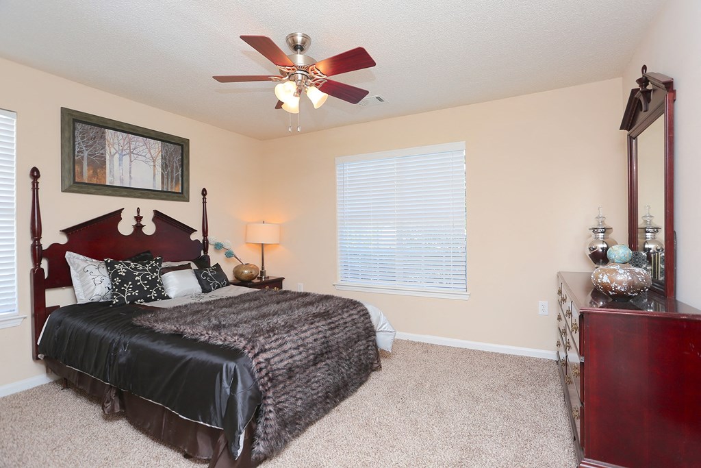 a bedroom with a large bed and a ceiling fan
