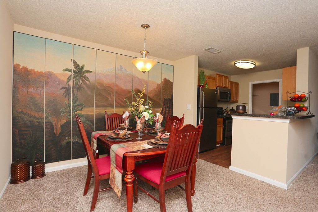 a dining room with a table and chairs and a kitchen