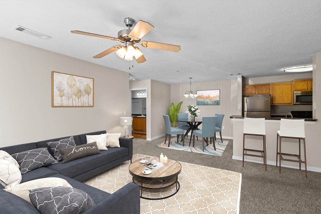 a living room with a couch and a coffee table and a dining room and kitchen