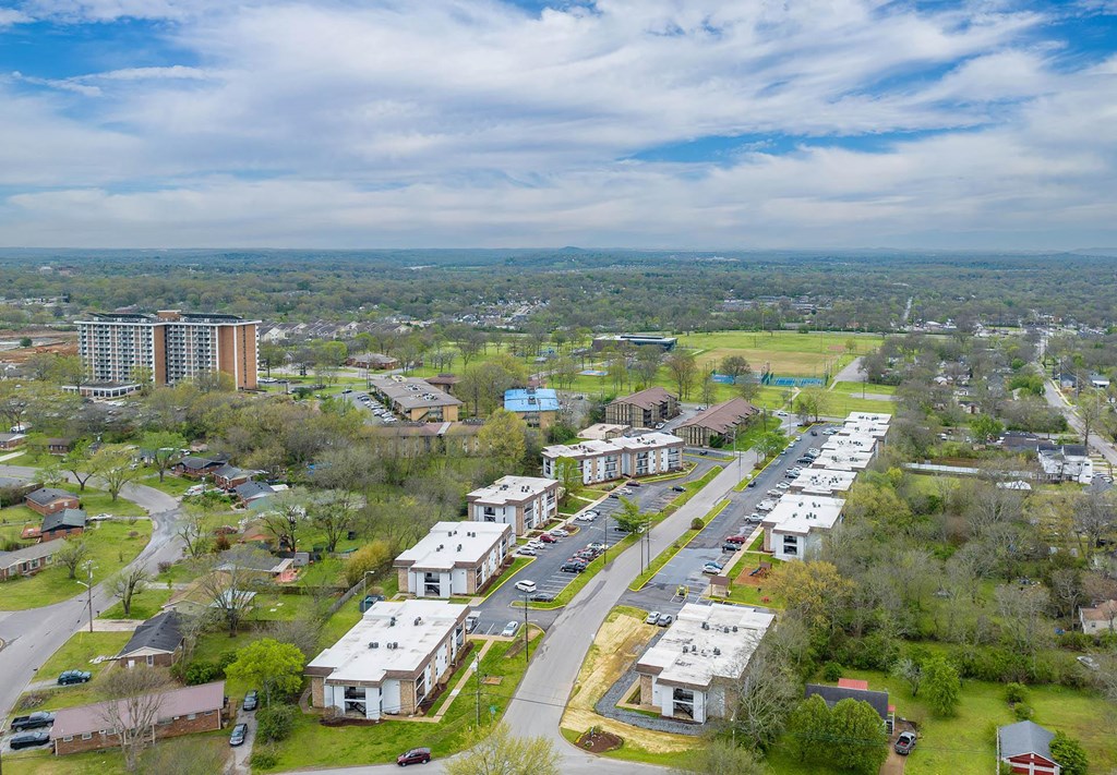 an aerial view of a city with a blue sky and white clouds