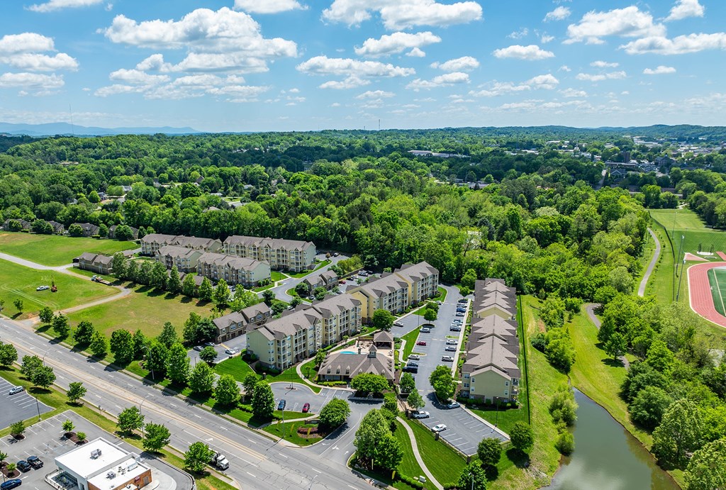 an aerial view of apartment buildings next to a body of water