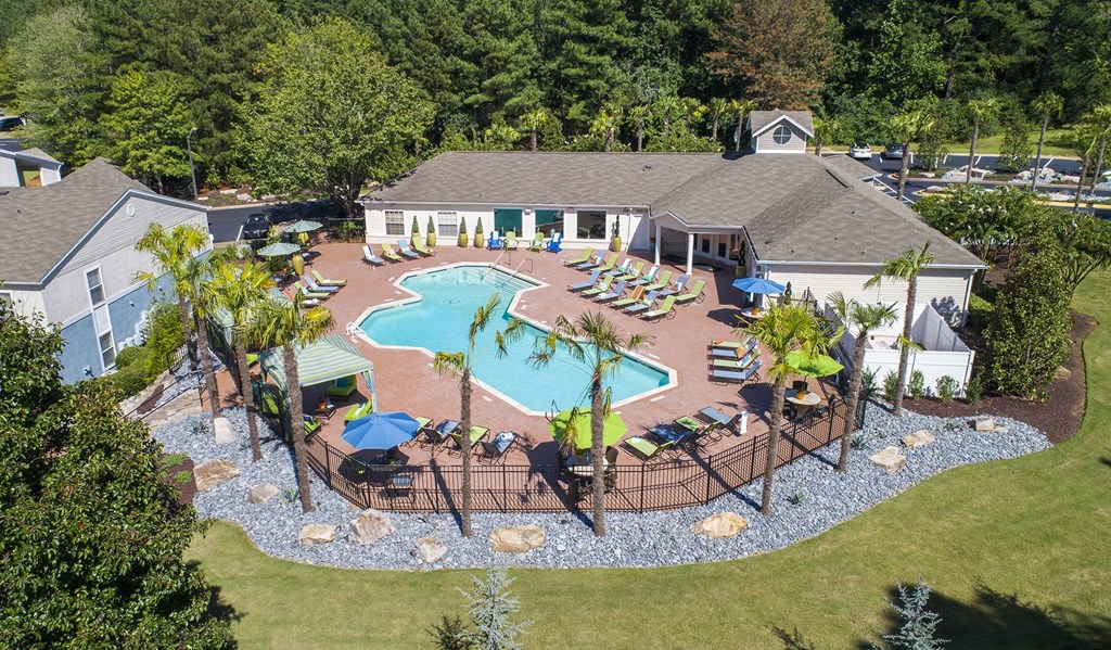 a aerial view of a pool with chairs and umbrellas