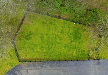 an aerial view of a grassy area with a fence around it