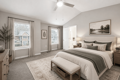 A bedroom with a large bed and a window with curtains.